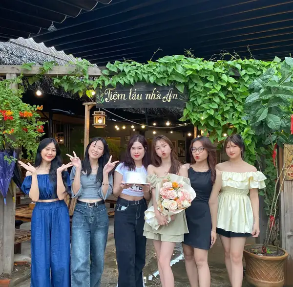 Nhóm bạn cầm hoa trong bữa tiệc tại tiệm